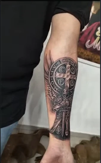 Tatuagem de São Miguel com cruz de São Bento no antebraço, feita no Cabala Tattoo Studio